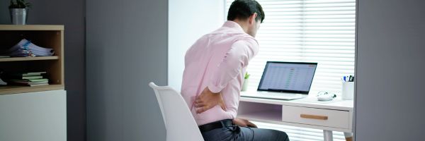 Man die met een verkeerde zithouding achter de computer zit