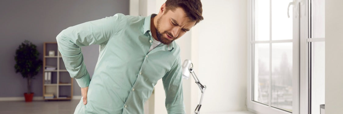 Man met rugpijn die oefeningen doet voor hernia herstel en houding verbeteren